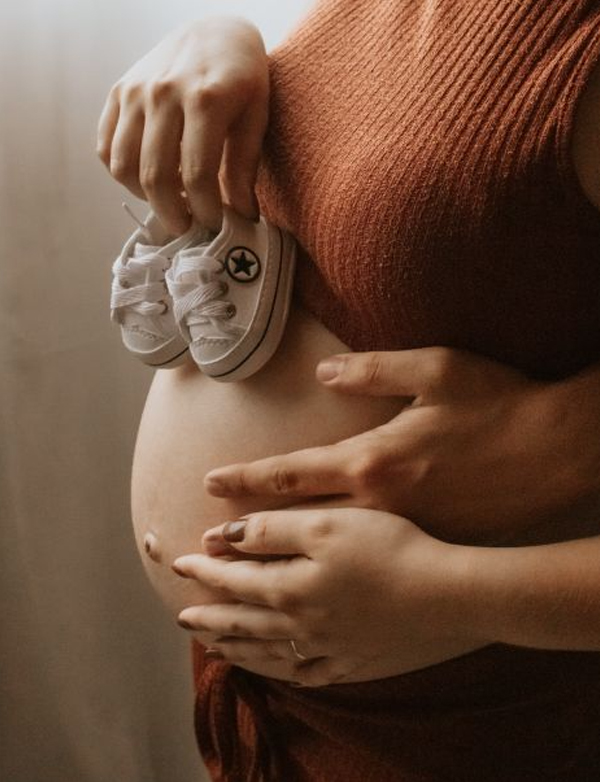 petits chaussons sur un ventre de femme enceinte
