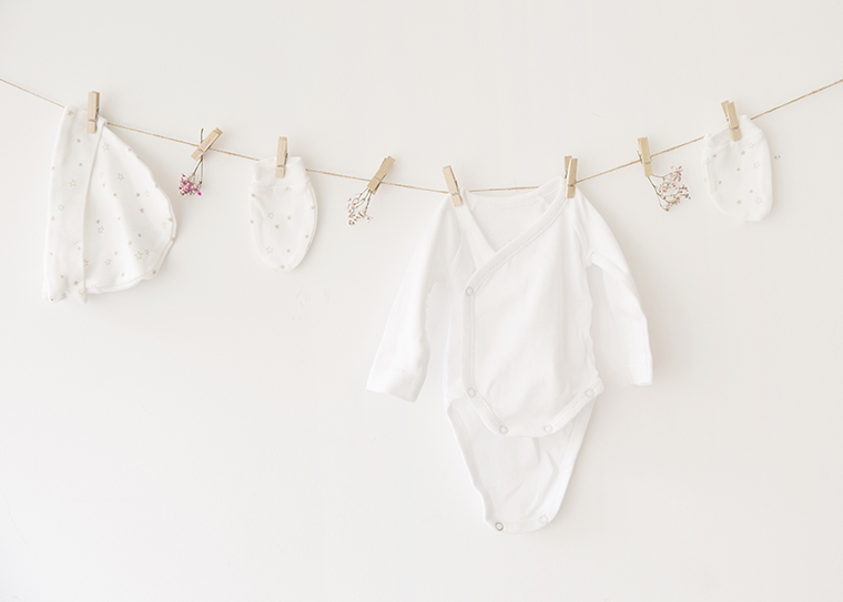 Vêtements de bébé blancs sur une corde à linge